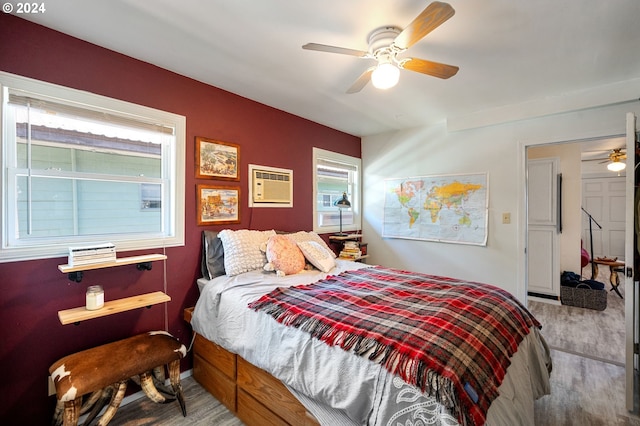 bedroom featuring ceiling fan, wood-type flooring, and a wall unit AC