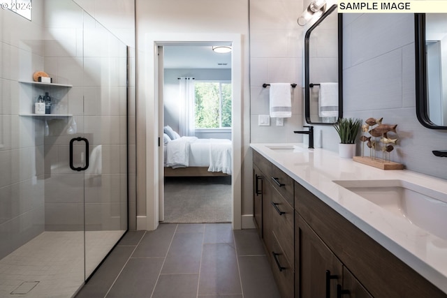 bathroom featuring tile patterned flooring, vanity, tile walls, and a shower with shower door