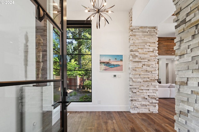 interior space with a chandelier, wood finished floors, and baseboards