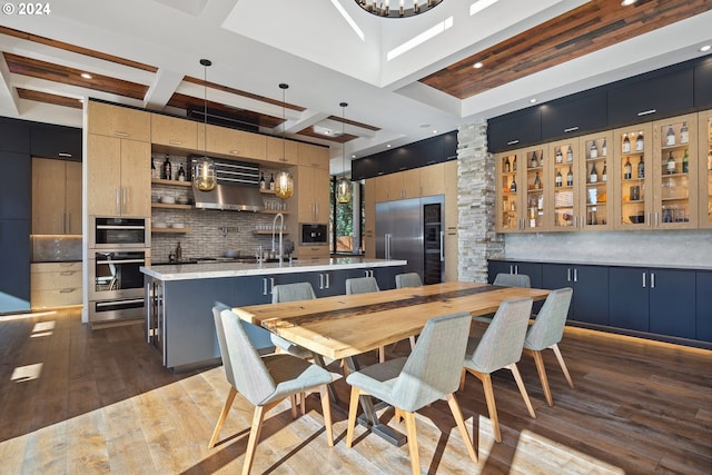 dining room featuring wet bar, beam ceiling, coffered ceiling, and dark hardwood / wood-style flooring