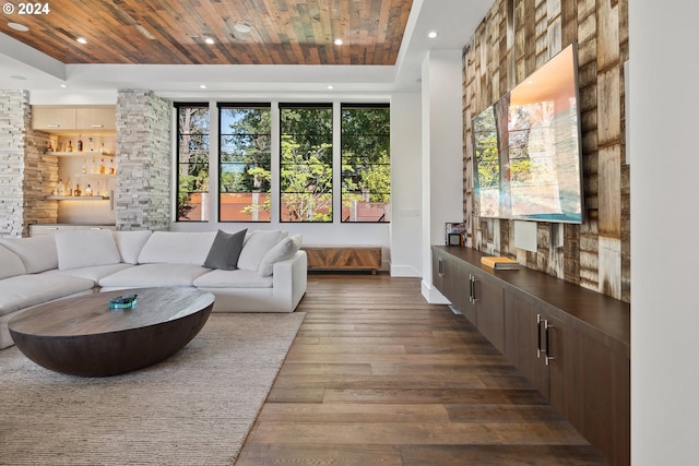 living area featuring baseboards, a raised ceiling, dark wood-style flooring, wood ceiling, and recessed lighting