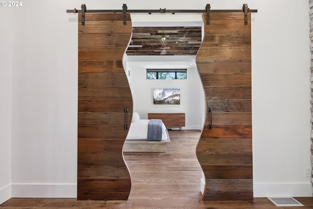 details featuring a barn door and hardwood / wood-style flooring