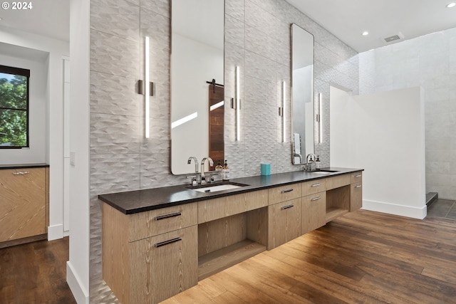 bathroom featuring vanity, tile walls, a shower with door, and hardwood / wood-style floors