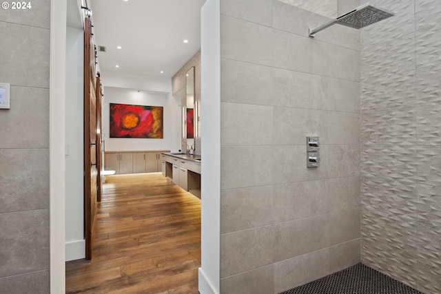 corridor featuring recessed lighting, a barn door, and wood finished floors