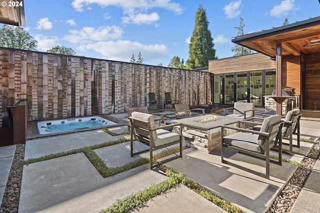 view of patio / terrace with a fire pit and an outdoor hot tub
