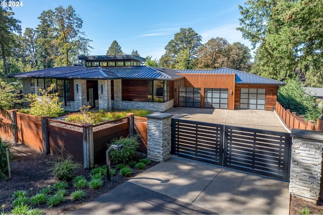 view of front of house featuring a standing seam roof, metal roof, and stone siding