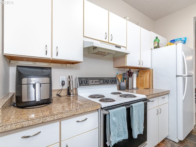 kitchen featuring a textured ceiling, white cabinets, and white appliances