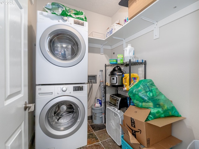 clothes washing area with stacked washer / dryer and a textured ceiling