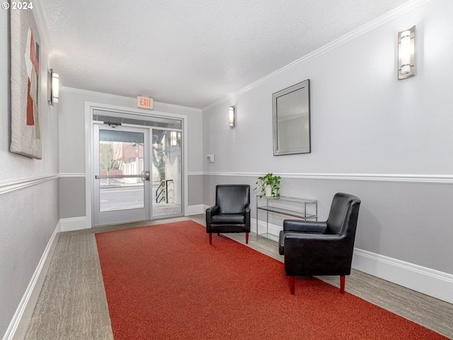 living area with crown molding and hardwood / wood-style flooring