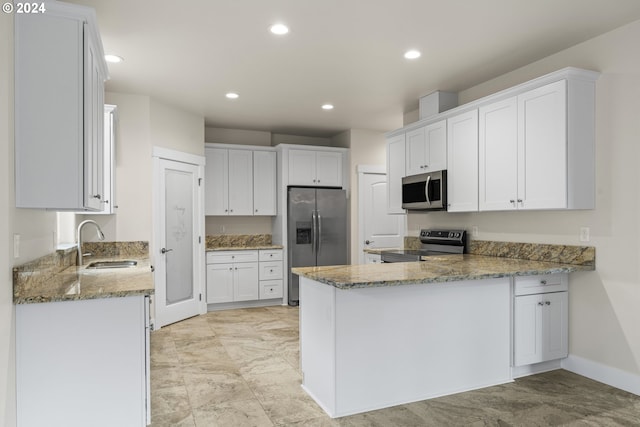 kitchen with sink, stainless steel appliances, white cabinets, and stone countertops