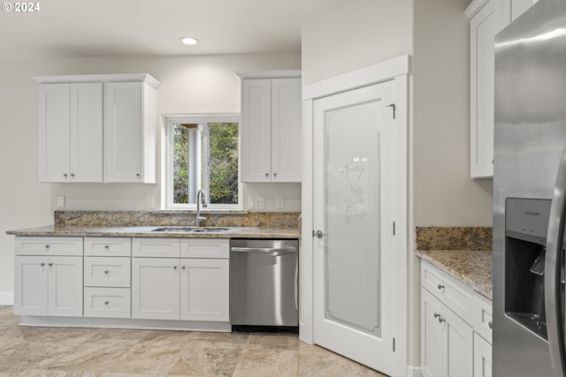 kitchen featuring white cabinetry, sink, light stone counters, and stainless steel appliances