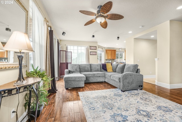 living room featuring a textured ceiling, dark hardwood / wood-style flooring, ceiling fan, and plenty of natural light