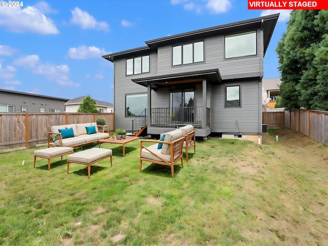 rear view of property featuring an outdoor living space and a lawn