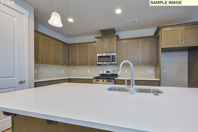 17374 SW Kalapuya Ln Unit 70, Sherwood, OR 97140 - kitchen featuring appliances with stainless steel finishes, a sink, light countertops, hanging light fixtures, and tasteful backsplash