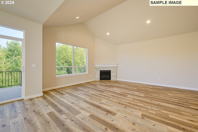 17374 SW Kalapuya Ln Unit 70, Sherwood, OR 97140 - unfurnished living room featuring vaulted ceiling, light wood-type flooring, healthy amount of natural light, recessed lighting, and a tiled fireplace