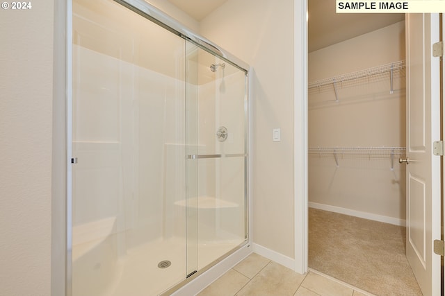 17374 SW Kalapuya Ln Unit 70, Sherwood, OR 97140 - bathroom with a stall shower, tile patterned flooring, a spacious closet, and baseboards