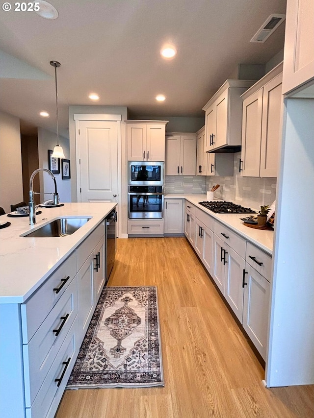17374 SW Kalapuya Ln Unit 70, Sherwood, OR 97140 - kitchen with stainless steel appliances, a sink, light wood-style flooring, light countertops, and recessed lighting