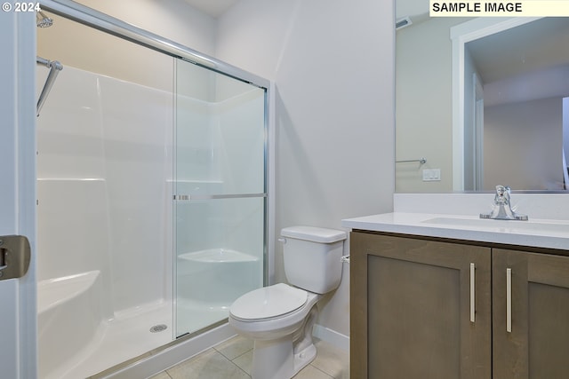 bathroom with vanity, a shower with shower door, tile patterned floors, and toilet