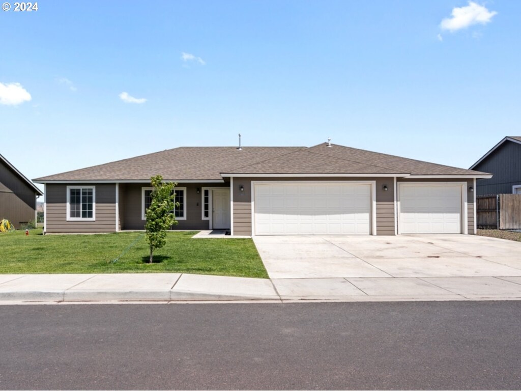 single story home featuring a front lawn and a garage