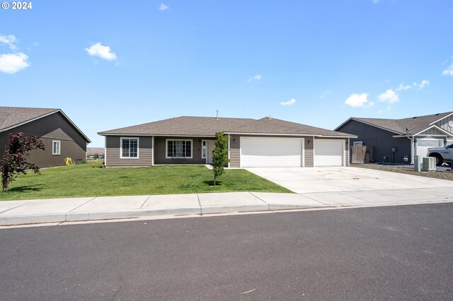 ranch-style house with central AC, a front yard, and a garage