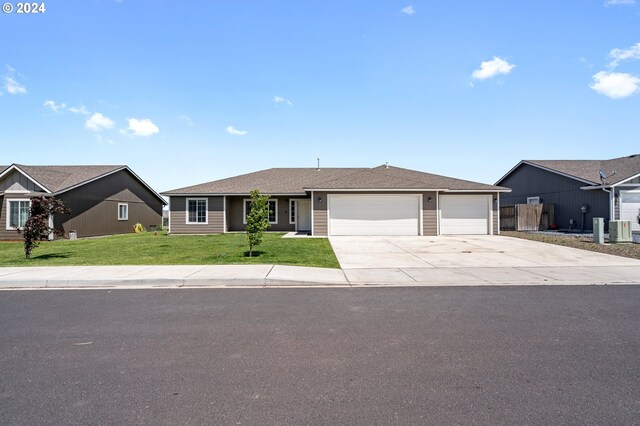 single story home featuring central AC unit, a garage, and a front lawn