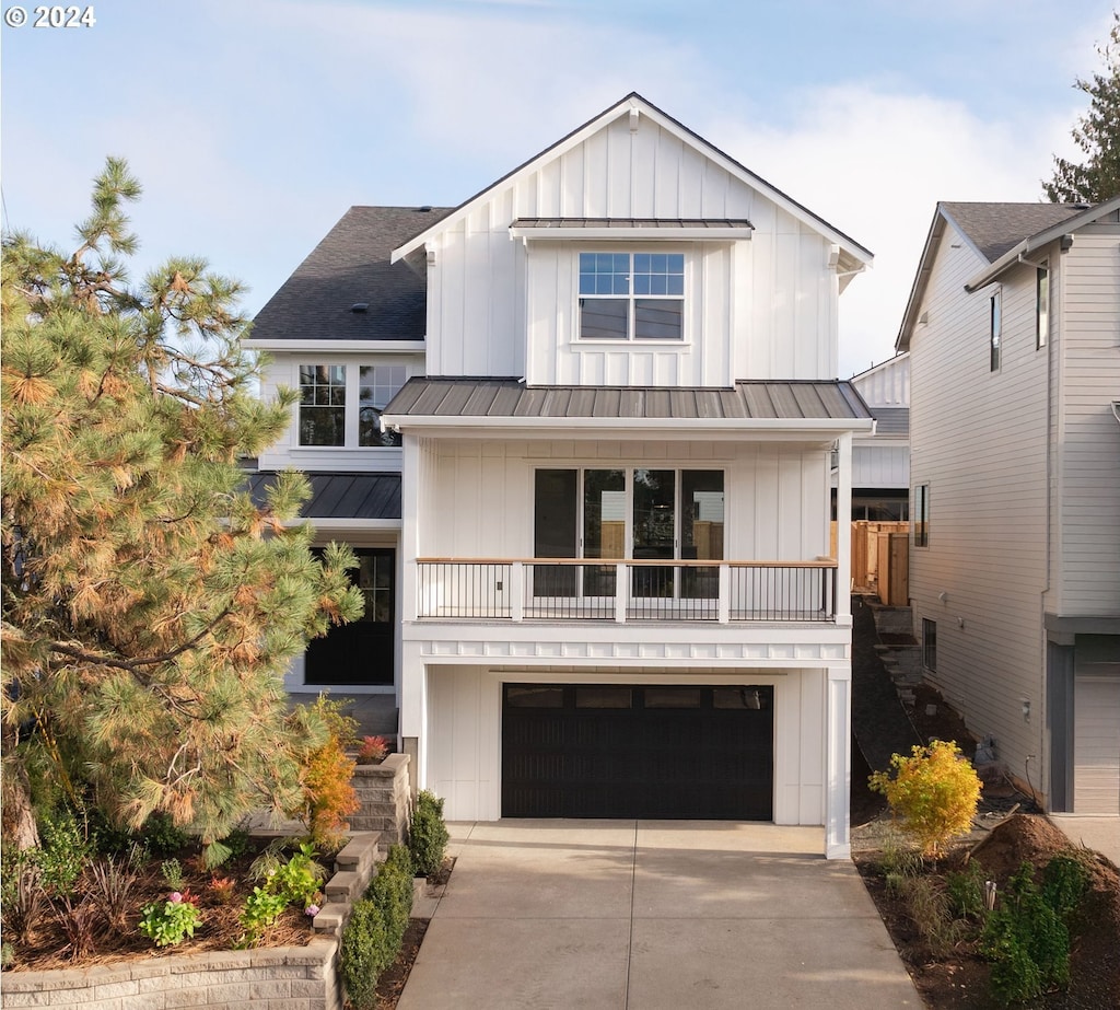 modern inspired farmhouse featuring a balcony and a garage