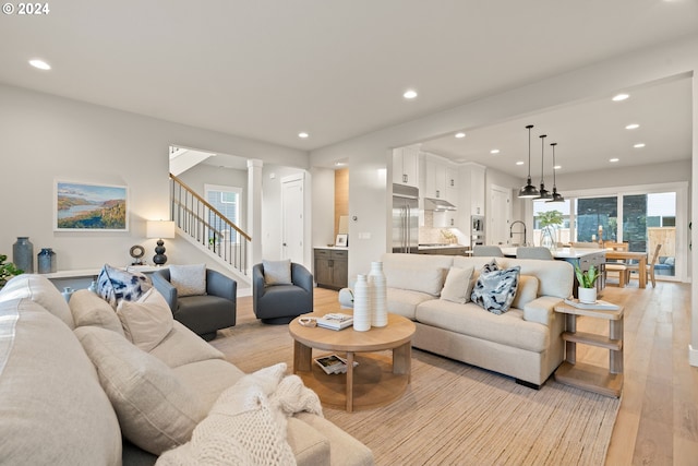 living room with light hardwood / wood-style floors and ornate columns