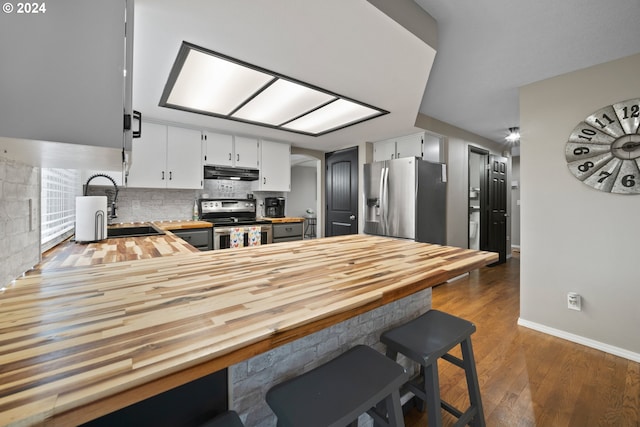 kitchen featuring dark hardwood / wood-style floors, stainless steel appliances, decorative backsplash, white cabinetry, and sink