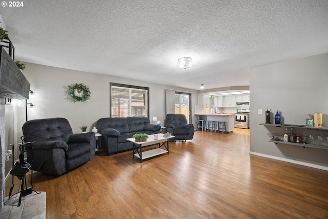 living room with a textured ceiling and hardwood / wood-style floors