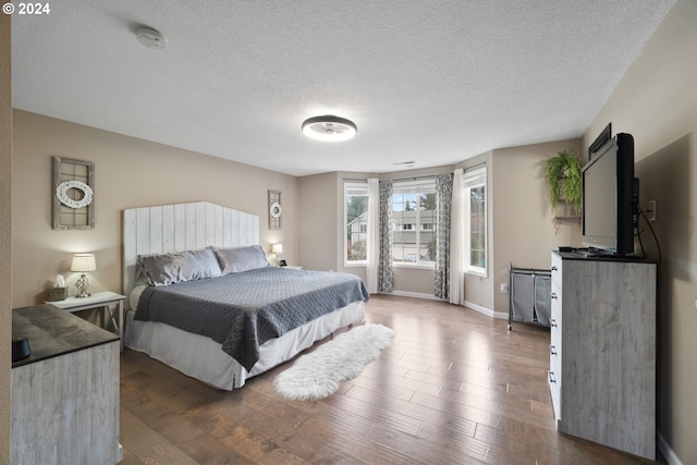 bedroom featuring a textured ceiling and dark wood-type flooring