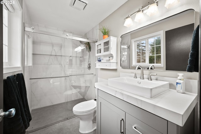 bathroom featuring toilet, a shower with door, and vanity