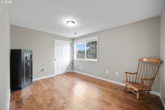 unfurnished room with a textured ceiling and hardwood / wood-style flooring