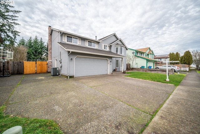 view of front of property with central AC, a front yard, and a garage