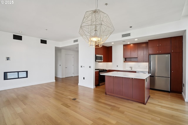 1025 NW Couch St Unit 716, Portland, OR 97209 - kitchen with stainless steel appliances, light wood-style floors, light countertops, open floor plan, and recessed lighting