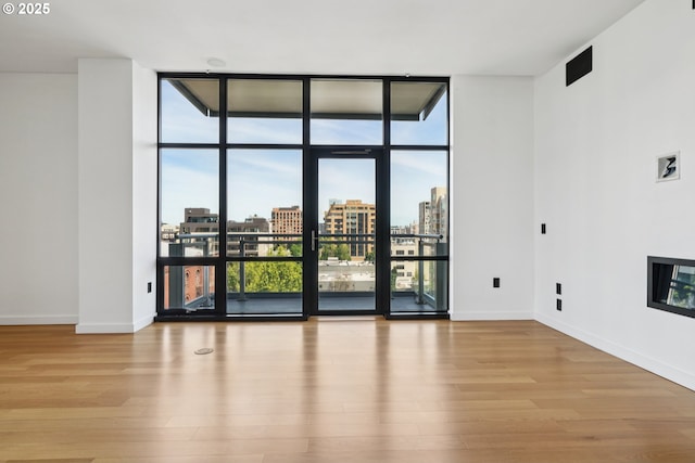 1025 NW Couch St Unit 716, Portland, OR 97209 - spare room with expansive windows, wood finished floors, and a city view