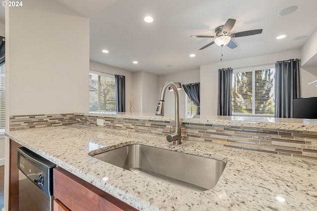 kitchen with stainless steel dishwasher, sink, a wealth of natural light, and tasteful backsplash