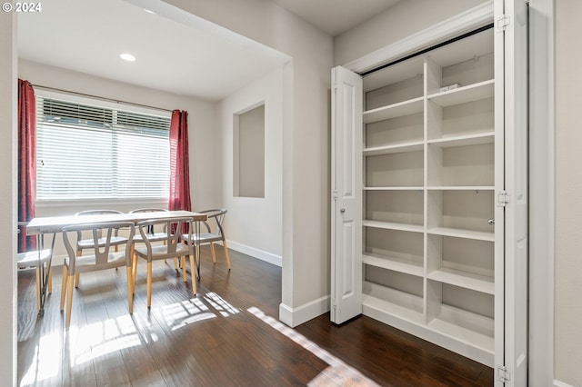 unfurnished dining area featuring dark wood-type flooring