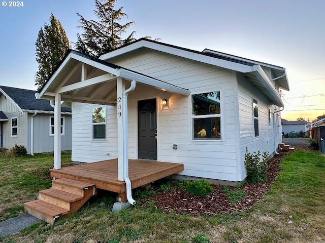 view of front of house with covered porch and a lawn