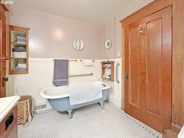 bathroom with tile patterned flooring, vanity, and a bathing tub