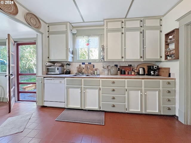 kitchen with sink, white cabinetry, dishwasher, crown molding, and decorative backsplash