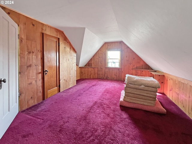 additional living space with lofted ceiling, carpet floors, and wood walls