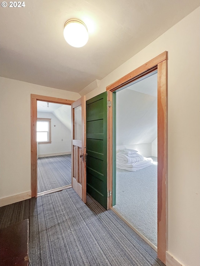 corridor featuring lofted ceiling and carpet