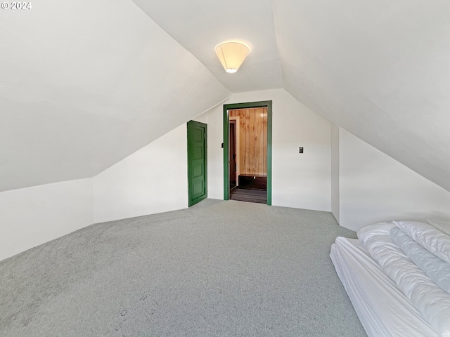 bonus room with lofted ceiling and carpet flooring