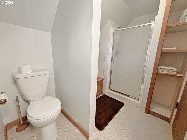 bathroom featuring lofted ceiling, toilet, and an enclosed shower