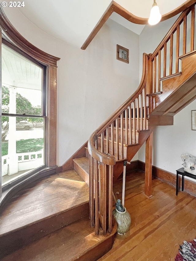 stairs featuring hardwood / wood-style floors