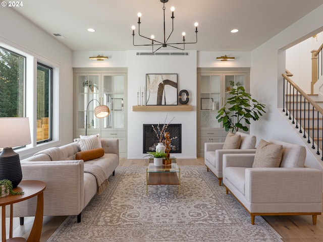 living room featuring a healthy amount of sunlight, light hardwood / wood-style floors, and an inviting chandelier