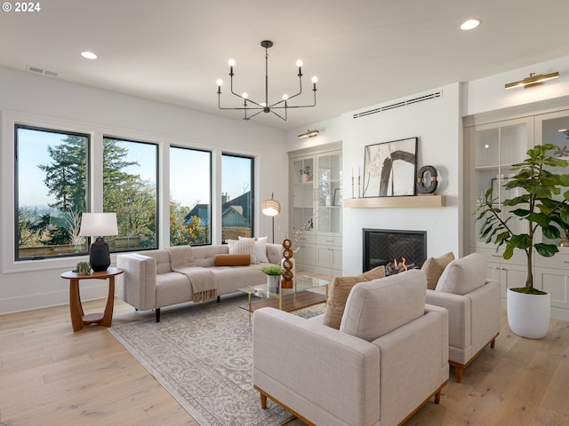 living room featuring a chandelier and light hardwood / wood-style flooring