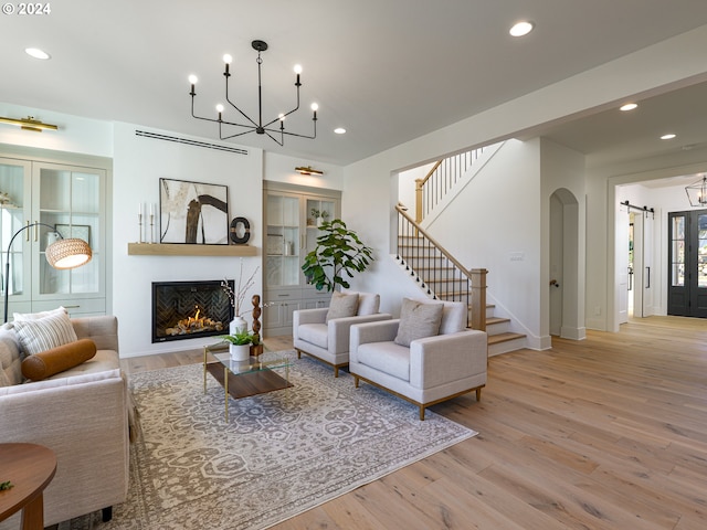 living room with an inviting chandelier and light hardwood / wood-style flooring