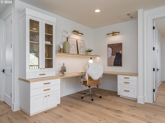 office featuring built in desk and light hardwood / wood-style flooring