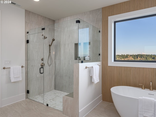 bathroom featuring tile patterned flooring and shower with separate bathtub